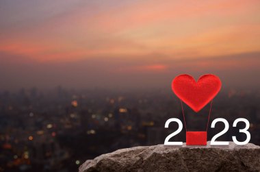 Kırmızı Kumaş Kalp, 2023 beyaz yazılı balonu sever. Sıcak gün batımında Rock Dağları 'nda. Mutlu yıllar ve Sevgililer Günü 2023 konsepti.
