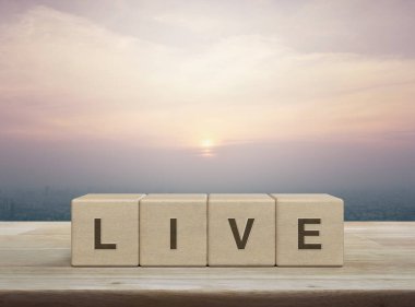 Live letter on wood block cubes on wooden table over city tower and skyscraper at sunset, vintage style, Technology broadcasting communication concept