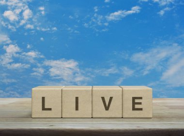 Live letter on wood block cubes on wooden table over blue sky with white clouds, Technology broadcasting communication concept
