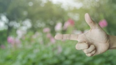 Güç düğmesi düz simgesi bulanıklık pembe çiçek ve parkta ağaç üzerinde parmak üzerinde iş kavramı başlatmak