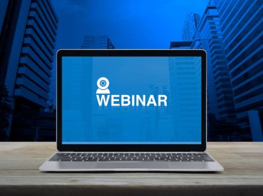 Modern dizüstü bilgisayar ekranındaki ikonu ofis kulesi ve gökdelen üzerindeki ahşap masa üzerine giyin, iş semineri online konsept