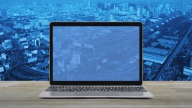 Modern dizüstü bilgisayar ekranında Wi-Fi düz ikonu ahşap masa üzerinde şehir kulesi, sokak, ekspres yol ve gökdelen, teknoloji internet kablosuz kavramı