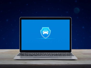 Modern dizüstü bilgisayar ekranında silikon simgesi olan araba fantezi gece gökyüzü ve ay üzerinde ahşap masa üzerinde ekranda, iş otomobili sigortası çevrimiçi konsepti