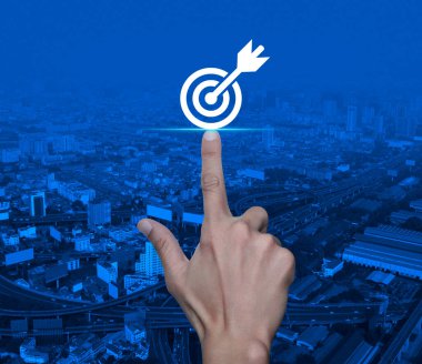 Modern şehir kulesi, sokak, ekspres yol ve gökdelen üzerinde dart ikonu ile el sıkışan hedef, iş başarısı konsepti