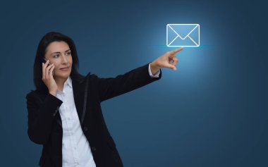 İş kadını, açık mavi arkaplan üzerinde el ile e- posta simgesine basın, İş dünyası bizimle çevrimiçi konsept ile iletişime geçin