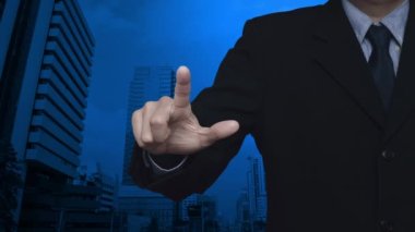 İş adamı modern ofis kulesi ve gökdelen üzerine ev ikonu basıyor, iş yeri gayrimenkul kavramı