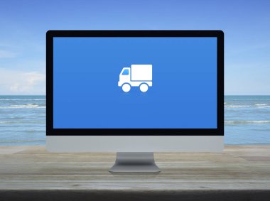 Masaüstü modern bilgisayar ekranında düz ikon dağıtım kamyonu beyaz bulutlu mavi gökyüzü, iş ulaşımı çevrimiçi servis konsepti üzerinde ahşap tablo üzerinde