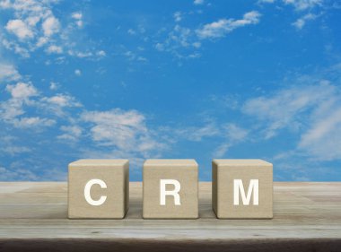 Tahta küpler üzerine CRM harfi mavi gökyüzü üzerinde beyaz bulutlar, Müşteri İlişkileri Yönetimi kavramı