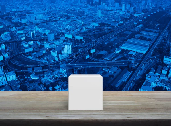 近代的な都市の塔 高速道路や超高層ビルの上の木製のテーブルの上に白いブロックキューブ — ストック写真