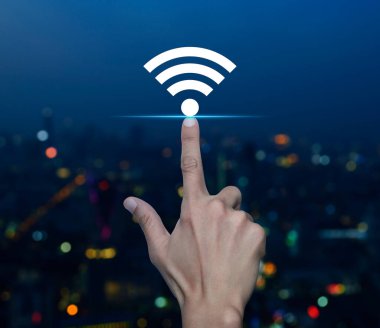 Wi-Fi düz simgesine bulanık gece aydınlığı modern şehir kulesi ve gökdelen, teknoloji internet iletişimi konsepti üzerine el ile basmak