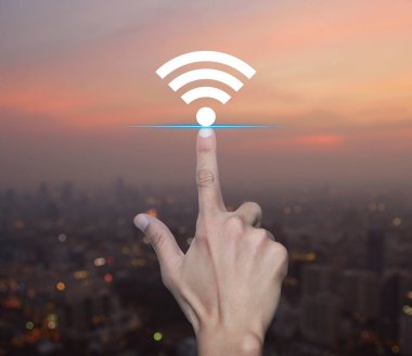 Sıcak gün batımında şehir manzarası bulanıklığı üzerine el ile Wi-Fi düz simgesi, Teknoloji İnternet iletişimi kavramı