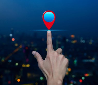 El ile haritanın nokta düğmesine basarak gece bulanık ışık modern şehir kulesi ve gökdelen, harita işaretleyici navigasyon konsepti üzerinde konum belirle