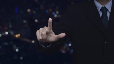 İş adamı, gece lambası, modern şehir kulesi ve gökdelen, iş otomobili sigorta kavramının üzerinde silikon simgesi olan arabaya baskı yapıyor.