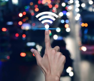 Şehirdeki renkli gece trafiği sıkışıklığı yolu üzerinde Wi-Fi simgesine elle basmak, Teknoloji İnternet iletişimi kavramı