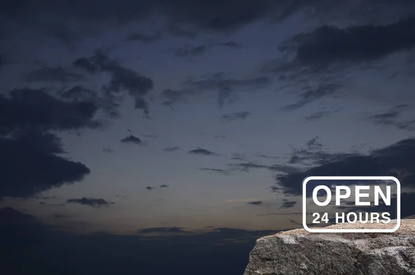 Open 24 hours icon on rock mountain over sunset sky, Business full time service concept
