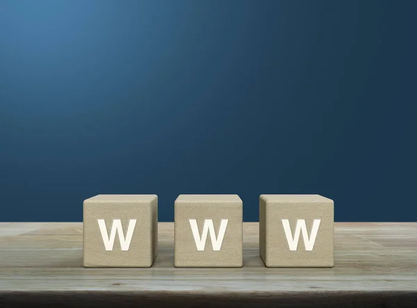 stock image WWW letter on wood block cubes on wooden table over light blue wall, Searching system and internet concept