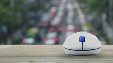Kablosuz bilgisayar faresinin üzerinde simgesi olan araç yoğun saatlerde ahşap masanın üzerinde, arabalar ve yollarla dolu, iş otomobili sigortası online konsepti.