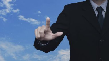 İş adamı, beyaz bulutlu mavi gökyüzü üzerinde ev ikonu olan çekiç ve anahtara basıyor.