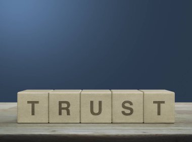 Tahta blok küplerdeki güven mektubu mavi duvardaki ahşap masa üzerinde güven işi konsepti oluşturuyor.