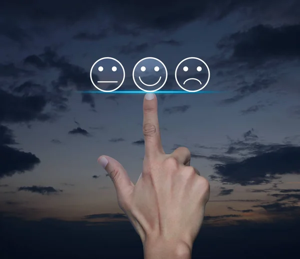 Hand pressing excellent smiley face rating icon over sunset sky, Business customer service evaluation and feedback rating concept