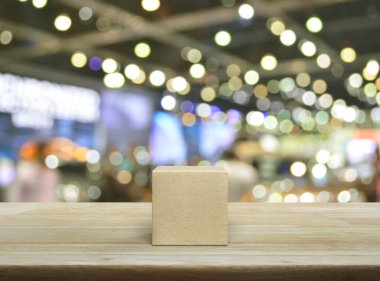 Ahşap blok küp ahşap masanın üzerinde bulanık ışık ve alışveriş merkezinin gölgesi