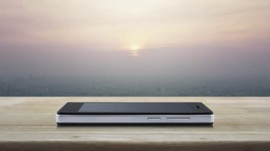 Elektrik düğmesi düz simgesi modern akıllı cep telefonu ekranında ahşap masa üzerinde ve günbatımında gökdelen, klasik tarzda, iş çevrimiçi konsept başlat