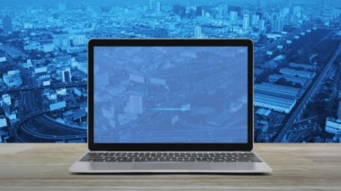 Düz simgeyi modern dizüstü bilgisayar ekranına, ahşap masaya, şehir kulesine, caddeye, ekspres yola ve gökdelene, teknoloji internet konseptine indir.