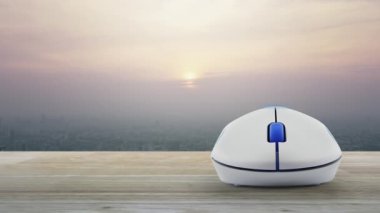 Modern şehir kulesinin üzerindeki tahta masa üzerinde kablosuz bilgisayar faresi ve günbatımında gökdelen, klasik tarzda, iş otomobili sigortası çevrimiçi konsepti.