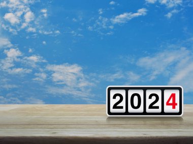 Beyaz bulutlu mavi gökyüzü üzerinde ahşap masa üzerinde 2024 metin ile ters saat, mutlu yeni yıl 2024 kapak konsepti