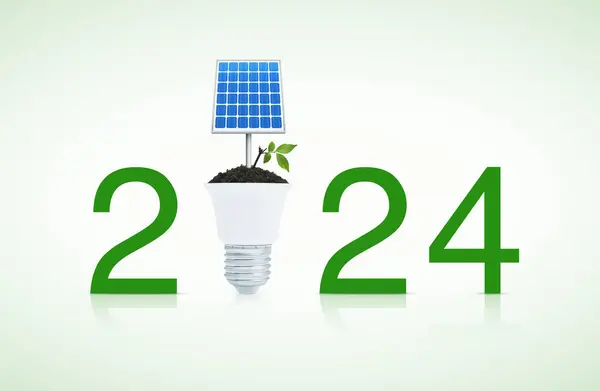 ソーラーセルと新鮮な緑の木が付いている2024テキストは白い背景の導かれた電球 幸せな新年2024の緑のエコロジーおよび省エネルギーの概念と土に残ります ロイヤリティフリーのストック画像