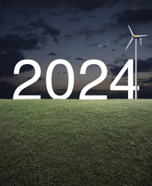 Günbatımında yeşil çimen tarlasında rüzgar türbini olan 2024 beyaz metin, Mutlu yıllar 2024 ekolojik kapak konsepti