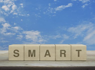 Tahta blok küplerdeki akıllı harf ahşap masanın üzerinde beyaz bulutlu, iş başarısı konsepti