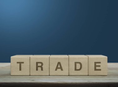 Ahşap blok küpleri üzerine ticaret mektubu mavi duvarın üzerindeki ahşap masa, iş yatırımı konsepti