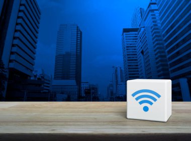 Wi-fi simgesi beyaz blok küp üzerinde ahşap masa üzerinde modern ofis kulesi ve gökdelen, Teknoloji internet iletişim konsepti