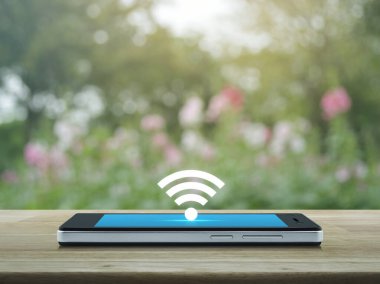Wi-fi düğmesi düz simge üzerinde modern akıllı cep telefonu ekranı ahşap masa üzerinde bulanık pembe çiçek ve ağaç parkta, teknoloji ve internet kavramı