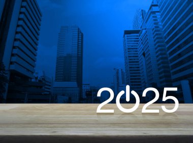 2025 Modern ofis kulesi ve gökdelen üzerinde ahşap masa üzerinde işletme ikonu kurun. Mutlu yıllar 2025 başarı konsepti.