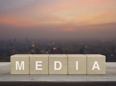 Tahta küpler üzerine medya mektubu. Şehir manzarasının bulanıklığı üzerine. Gün batımında, iş iletişimi kavramı.