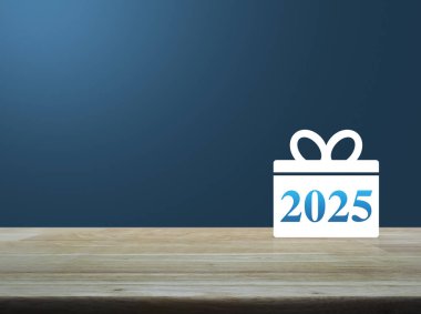 Hediye kutusu mutlu yeni yıl 2025 düz simge açık mavi duvar üzerinde ahşap masa üzerinde atölye online konsept