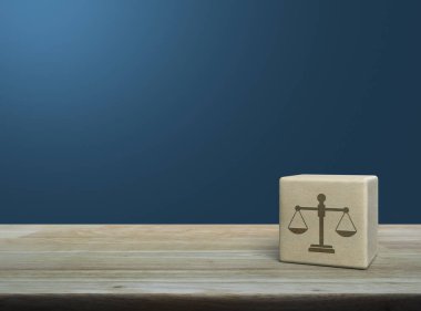 Ahşap blok küpün üzerindeki kanun simgesi açık mavi duvarın üzerindeki ahşap masa, iş hukuku hizmeti konsepti