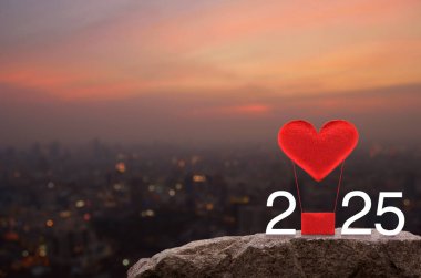 Kırmızı Kumaş Kalp, 2025 beyaz yazılı balonu sever. Sıcak gün batımında Rock Dağları 'nda. Mutlu yıllar ve Sevgililer Günü 2025 konsepti.