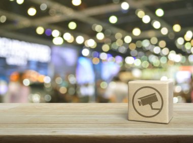 Kapalı devre kamera düz simgesi ahşap blok küp üzerinde bulanık ışık ve alışveriş merkezinin gölgesi, Teknoloji güvenliği ve güvenlik online konsepti üzerine