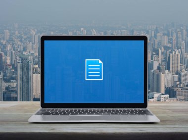 Modern dizüstü bilgisayar ekranındaki düz simge şehir kulesi ve gökdelen üzerindeki ahşap masa üzerindeki ekranda, Teknoloji iletişimi çevrimiçi konsepti