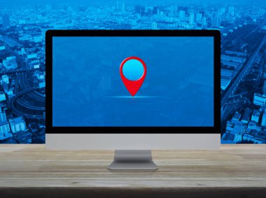 Harita nokta konum düğmesi üzerinde bilgisayar monitörü ekranı ahşap masa üzerinde şehir kulesi, sokak, ekspres yol ve gökdelen, Teknoloji haritası işaretleyici çevrimiçi konsept