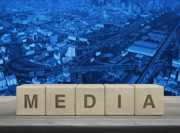 Tahta blok küplere basılı medya mektubu modern şehir kulesi, sokak, ekspres ve gökdelen üzerinde ahşap masa üzerinde iş iletişimi konsepti