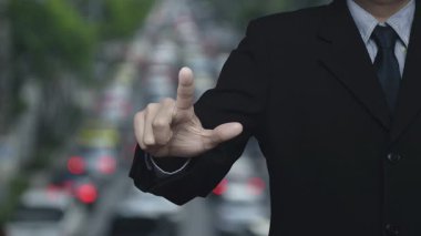 İş adamı, şehir içi otomobiller ve yollarla yoğun saatlerde ev ikonu basıyor, iş yeri emlak kavramı