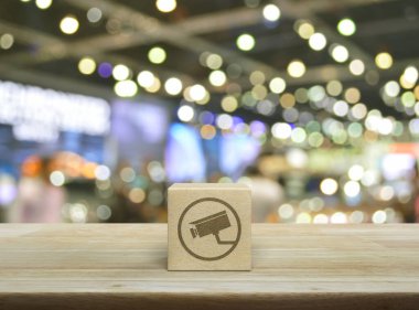 Kapalı devre kamera düz simgesi ahşap blok küp üzerinde bulanık ışık ve alışveriş merkezinin gölgesi, Teknoloji güvenliği ve güvenlik online konsepti üzerine