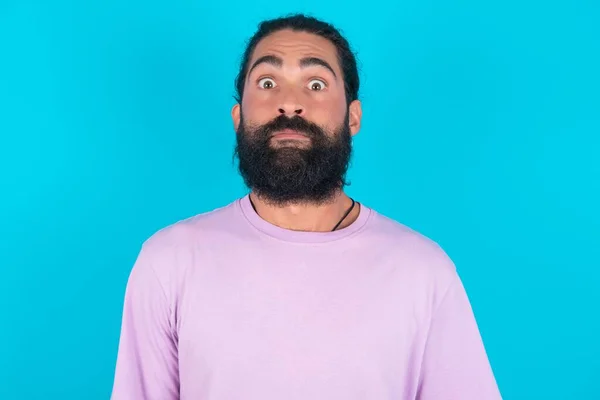 Förbluffad Vit Man Med Skägg Bär Violett Shirt Över Blå — Stockfoto
