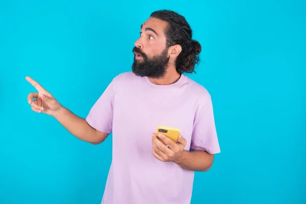 Homem Caucasiano Atordoado Com Barba Vestindo Camiseta Violeta Sobre Pontos — Fotografia de Stock