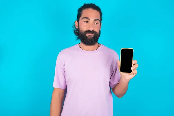 Caucasian Man Beard Wearing Violet Shirt Blue Background Holds New — Stock Photo, Image
