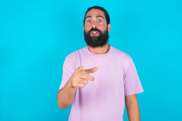 Shocked Caucasian Man Beard Wearing Violet Shirt Blue Background Points — Stock Photo, Image